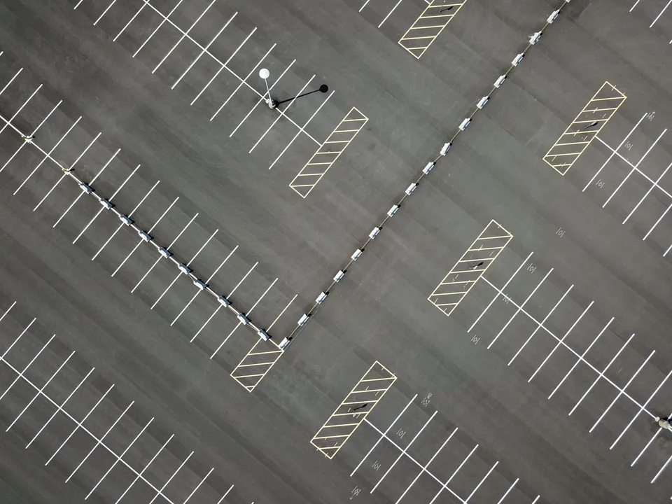 An aerial view of a vast, empty parking lot in Maplewood, MN, showcasing patterns and lines.